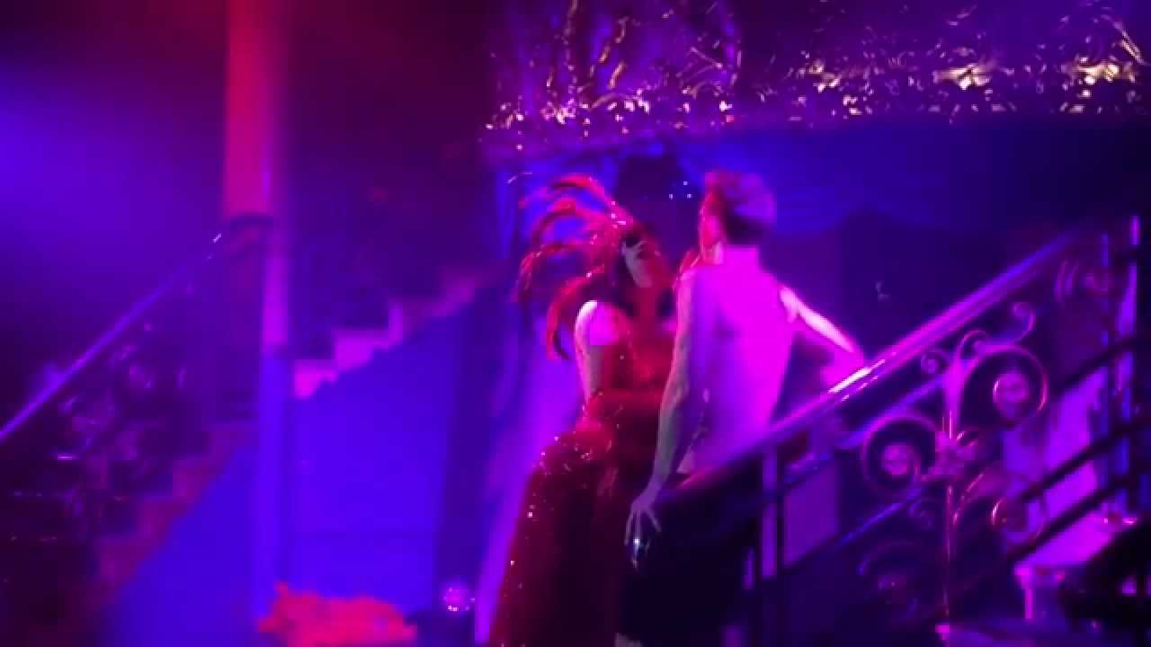 Performers on the staircase at Café de Paris during Cabarét Dés Distractions, lit in purple